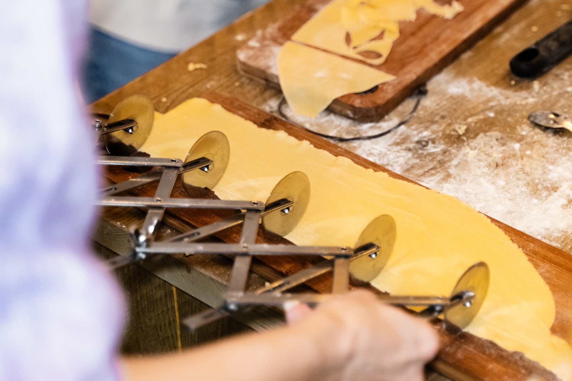 Fresh pasta being cut with a rolling cutter